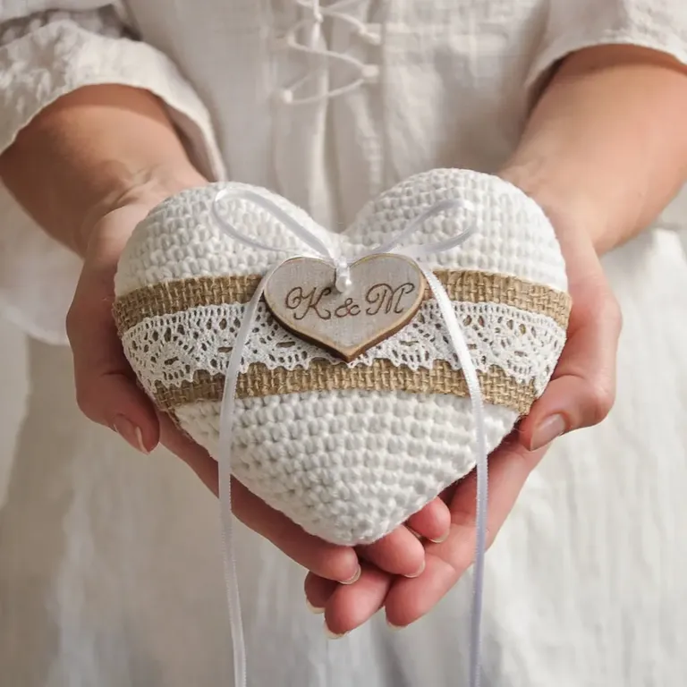 White crochet heart shaped ring bearer pillow with couples initials