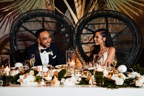 Bride and Groom in Black Rattan Sweetheart Chairs at Table With Candles