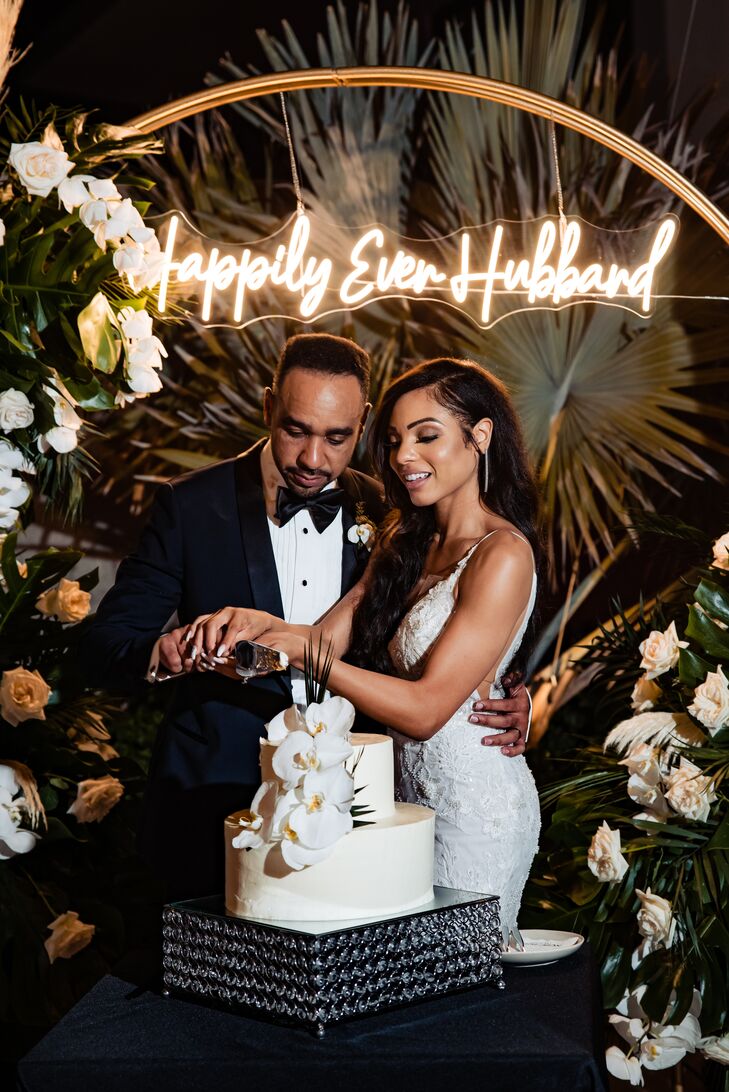 Bride and Groom Cut Cake at Tropical Destination Wedding With Custom Neon Sign