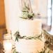 The three-tier wedding cake covered in cream-cheese icing had leaves rimmed around the base of each layer, in addition to decorating the top. The cake was filled with lemon, banana and carrot-cake flavors.