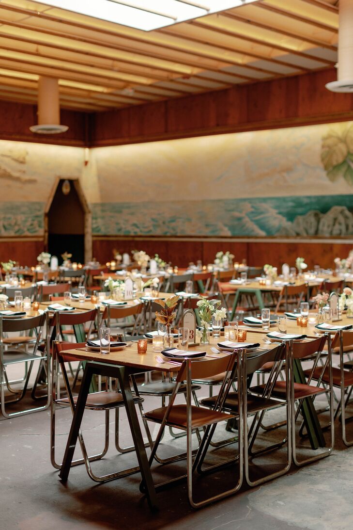 Indoor Reception With Mural, Long Wood Tables, Wood Chairs With Minimalistic, Low Centerpieces
