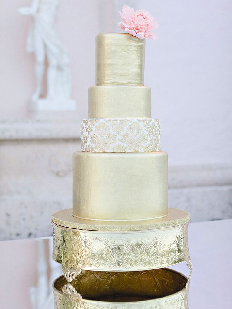 Glamorous metallic gold wedding cake with a pink peony