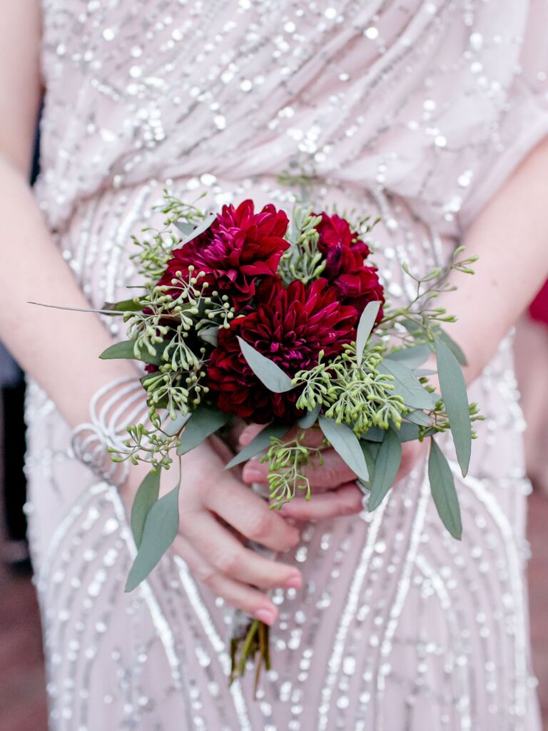 A bride holds this vibrant wine-colored bouquet.
