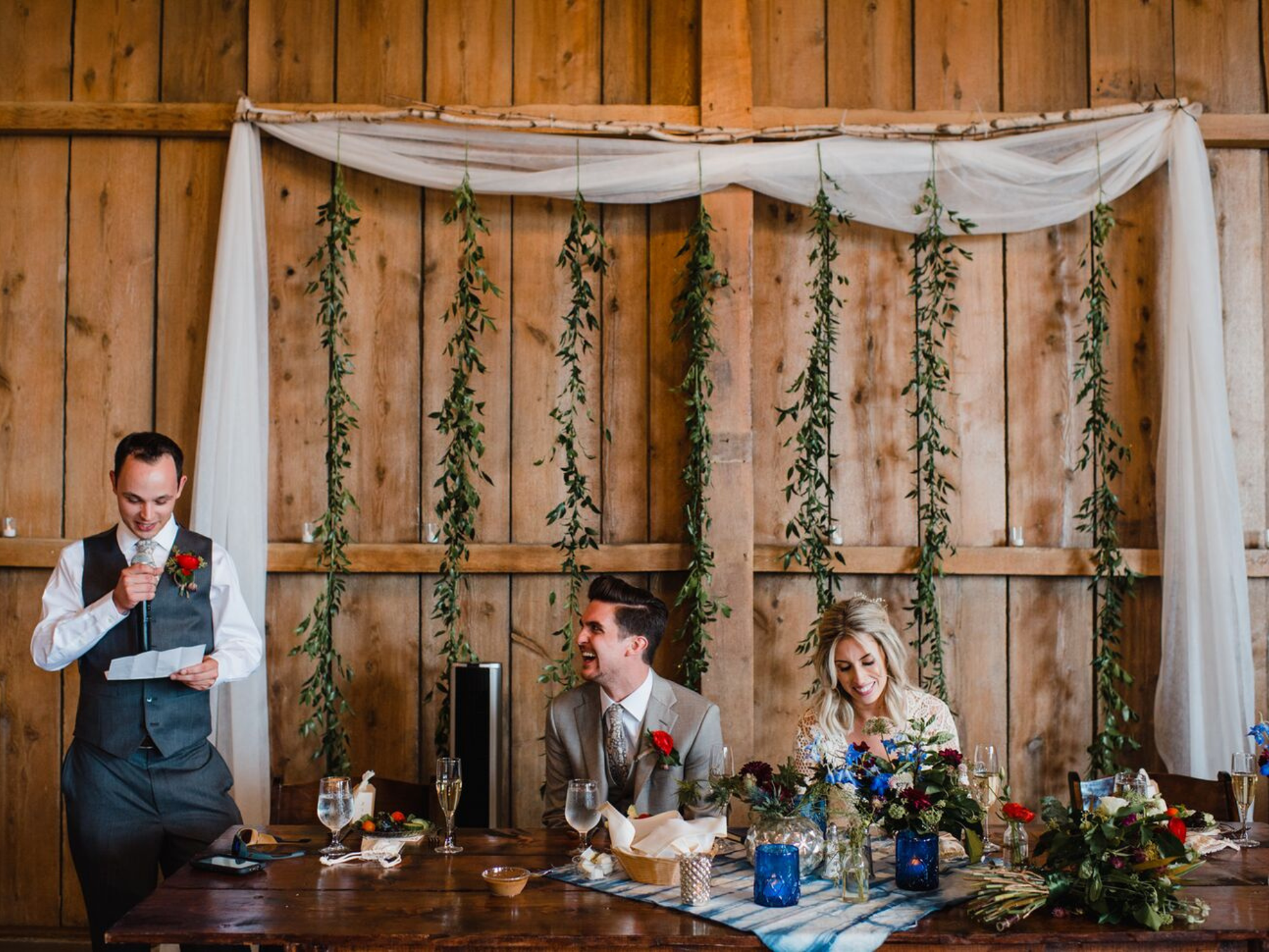 Bride and groom listening to groomsmen's speech at wedding