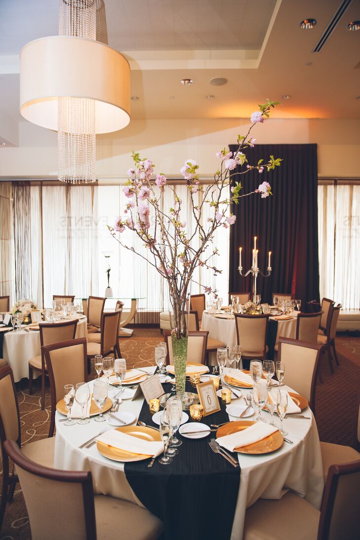 Pamela and Dan opted for not one but three centerpiece designs in their reception. Fleurescent, their florist, arranged the tallest with romantic cherry blossom branches. Green beading within its trumpet-style vase highlighted the display’s leaves and natural design.