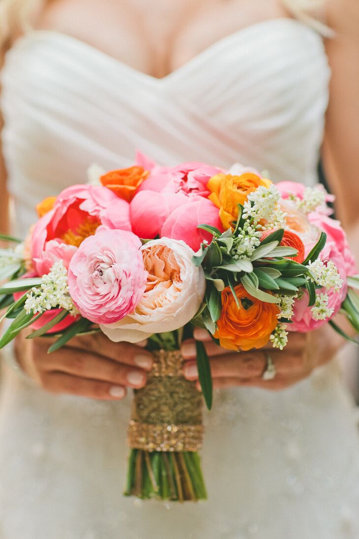 Kendrick's bouquet mixed bright pink and orange ranunucluses, tulips and peonies with soft peach garden roses, delicate white lilac and olive leaves for a cheerful-yet-sophisticated look. The bouquet was wrapped with gold-sequined ribbon to tie into the glam theme of the day.