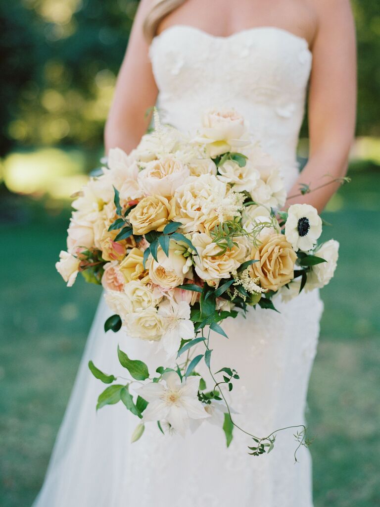 pale yellow wedding bouquet with garden roses, peonies and white clematis vines