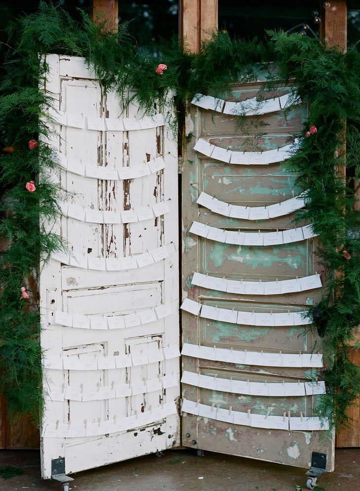 Katharine and Nate added antique furnishings and accents to their decor, using two vintage doors adorned with fluffy green garland as a backdrop against which to display their escort cards.