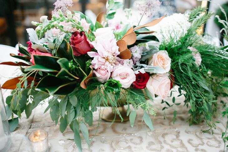 High and low centerpieces and candles were paired on the different reception tables for a gorgeous mismatched look that added plenty of dimension to the room. The silver and gold vases, bowls and candelabras added plenty of drama to the botanical look.