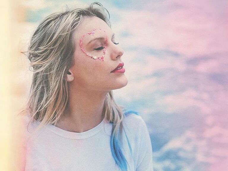 Taylor Swift in blue sweater with pink glitter heart around her eye for album art for Lover