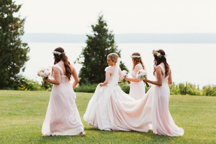 Sticking with tradition, Katherine’s bridesmaids wore matching floor-length gowns by Bill Levkoff in a soft shade of blush pink. Airy chiffon fabric, delicate gathering at the bodice and a one-shoulder neckline lent the gowns an ethereal grecian quality that fit perfectly with the wedding’s romantic vibe. The girls completed their look with shimmery sandals, rose gold earrings and lush baby’s breath flower crowns.rn