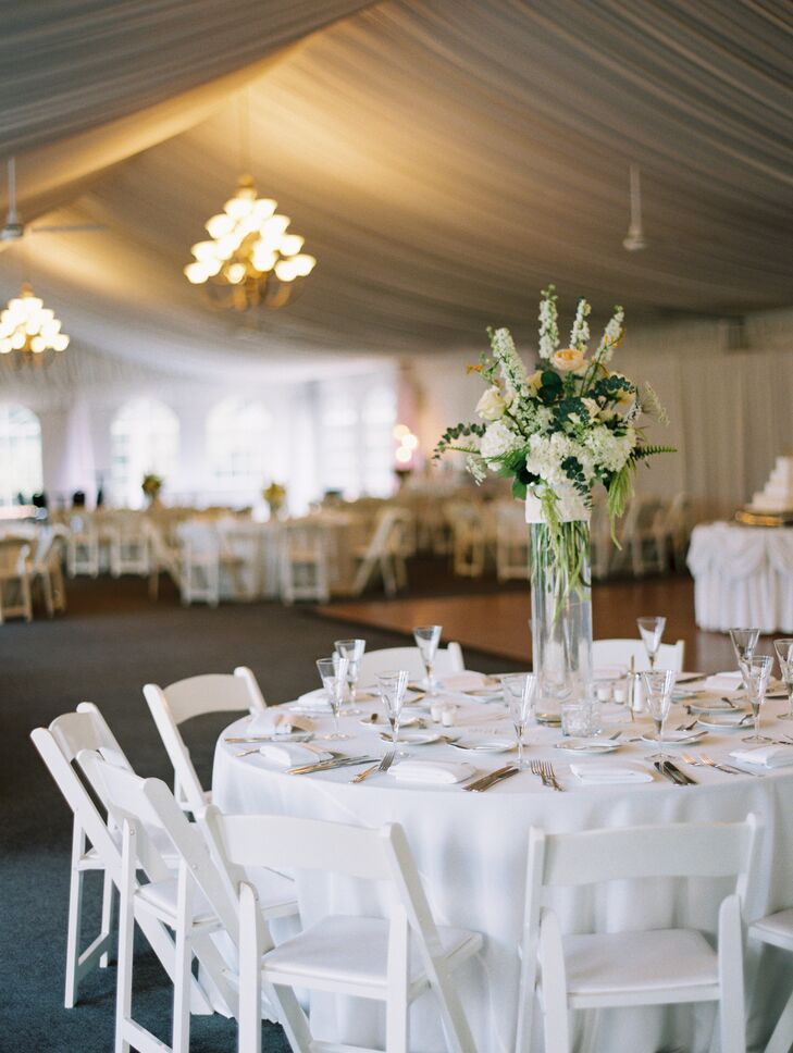 The bride collected all the floral vases so that no two  dining tables looked alike at the reception. The flowers matched the bouquets but were enlarged, and each table held four candles to create a romantic, intimate ambience. The couple also had custom table numbers: Each had the couple’s names written in gold font with a blush or gold number.