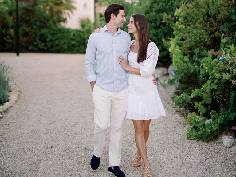 Couple walking through wine vineyard at their engagement party