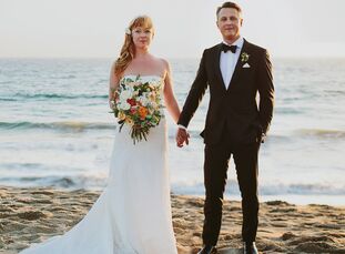Gwynne Crowley (35 and a freelance producer) and David Lowrie-Reed (40 and in marketing) exchanged vows under a dream catcher wedding arch on the sand