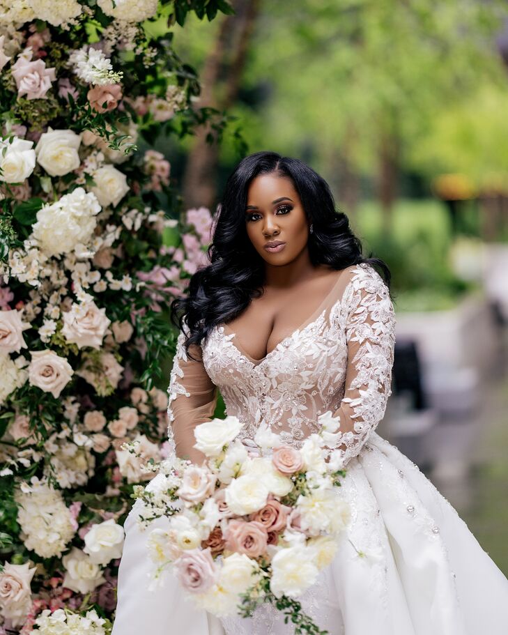 A Bride in a Dress With a Plunging Neckline, Illusions Sleeves and White-and-Pink Bouquet