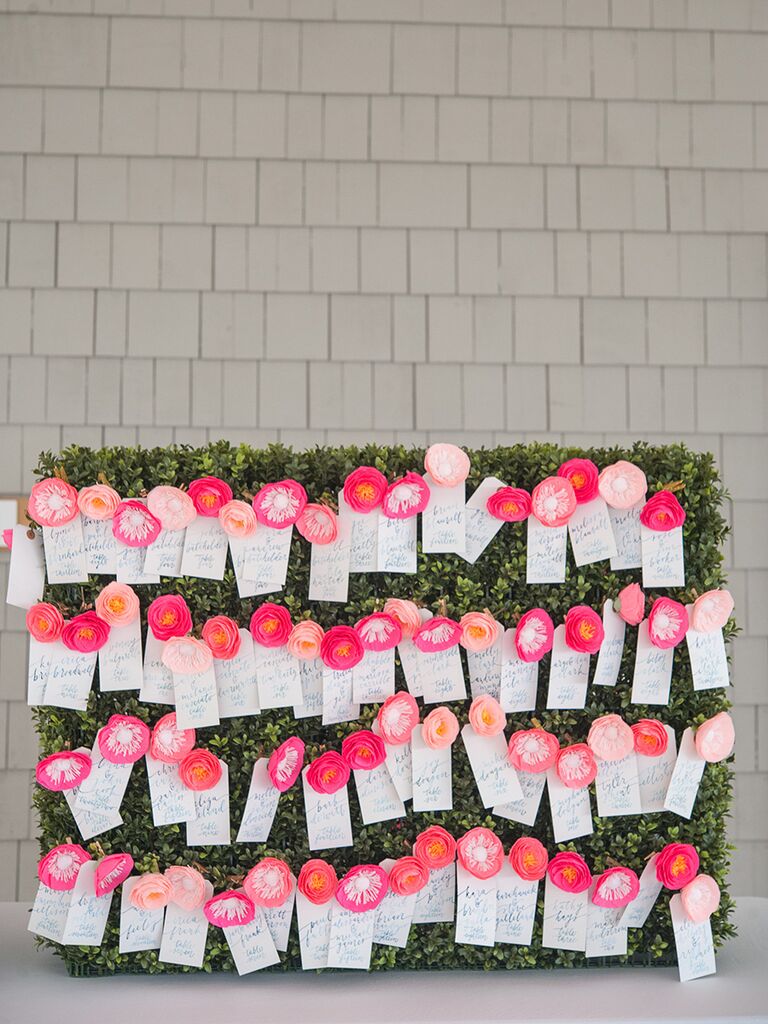 Bright pink paper flower escort card display