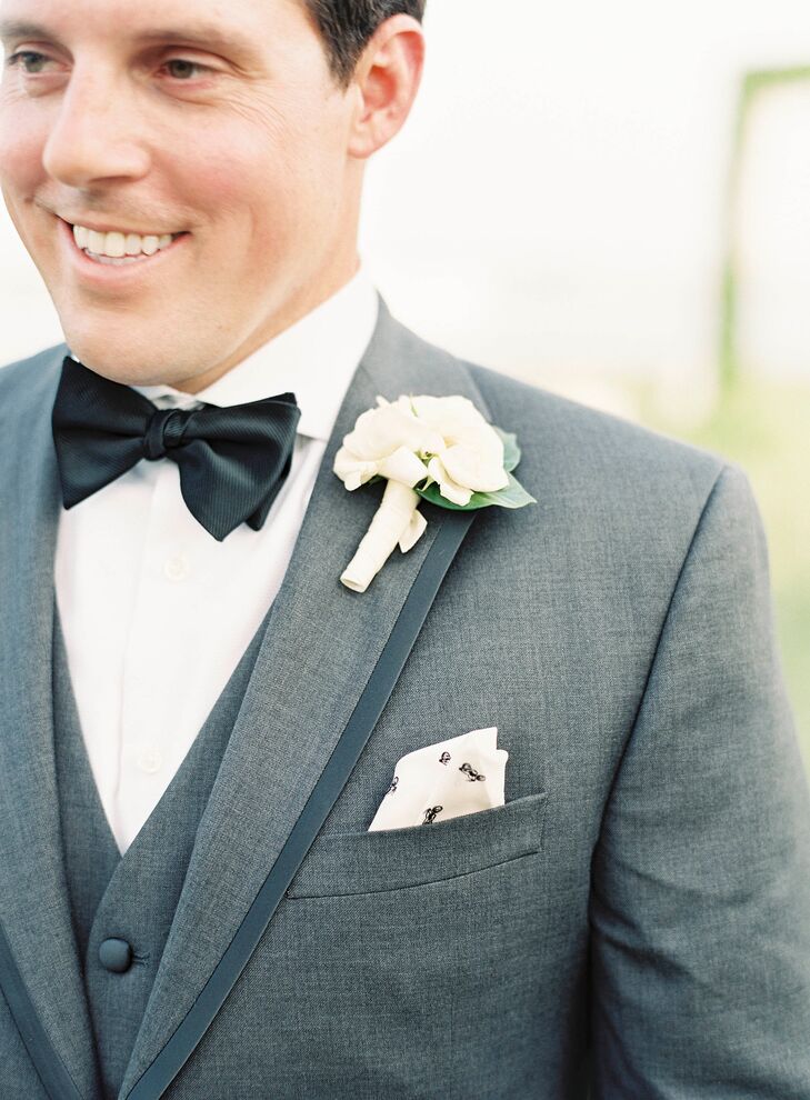 The groom sported a Black by Vera Wang dark gray slim-fit tuxedo, perfect for the couple's alfresco black-tie affair. Ryan accessorized with a simple garden rose boutonniere and light gray socks that were adorned with red and navy blue anchors, a nod to their nautical venue.