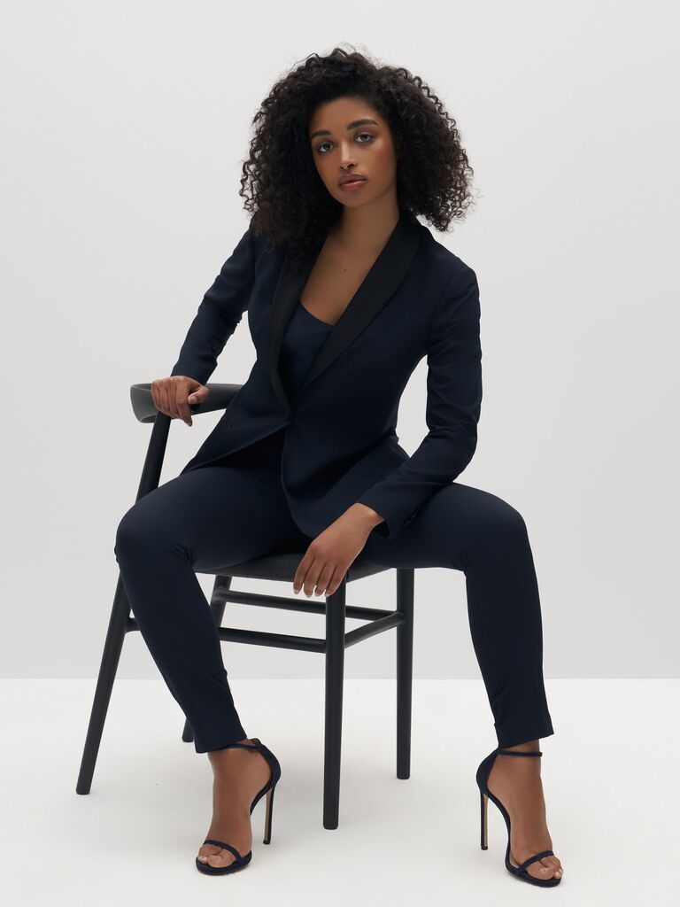 Model wears a women's navy tuxedo by SuitShop. 