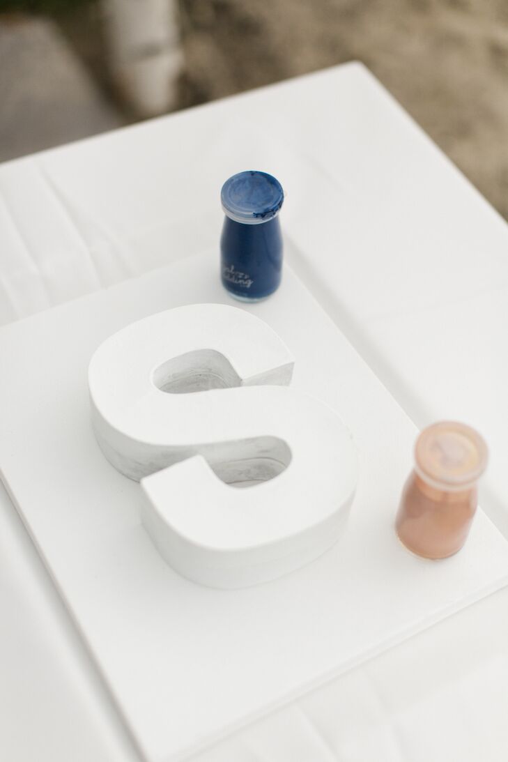 Instead of a traditional Chinese tea ceremony, Priscilla and Daniel opted for a custom unity paint ceremony during their wedding. Together, they poured rose gold and navy paint over a white S, representing his last initial. (The tea ceremony came later at their second reception, in Hong Kong.)