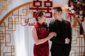 Bride in Red-and-Black Gown and Red Hair Clip With Groom in All-Black Suit and Red Boutonniere