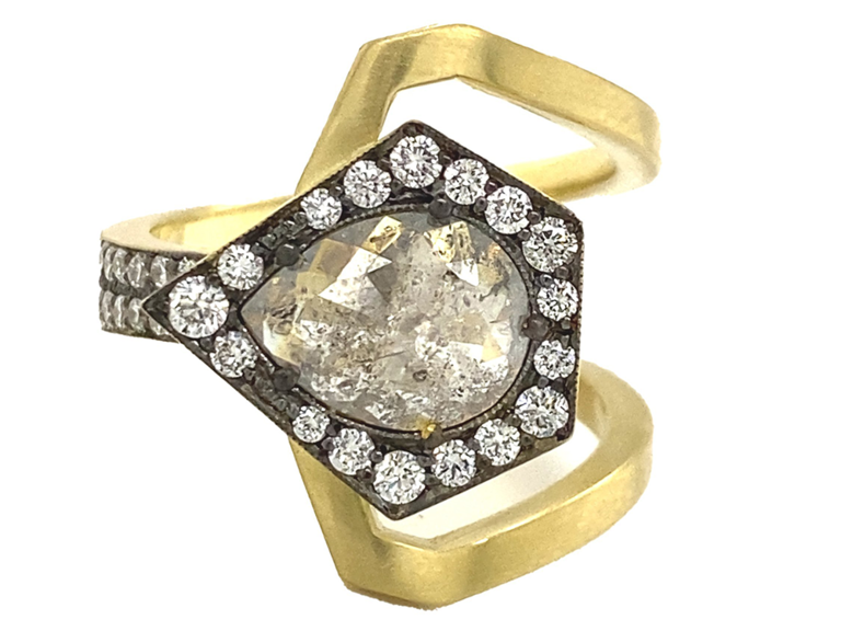 Pear shape rough cut center diamond with diamond halo and gold geometric band