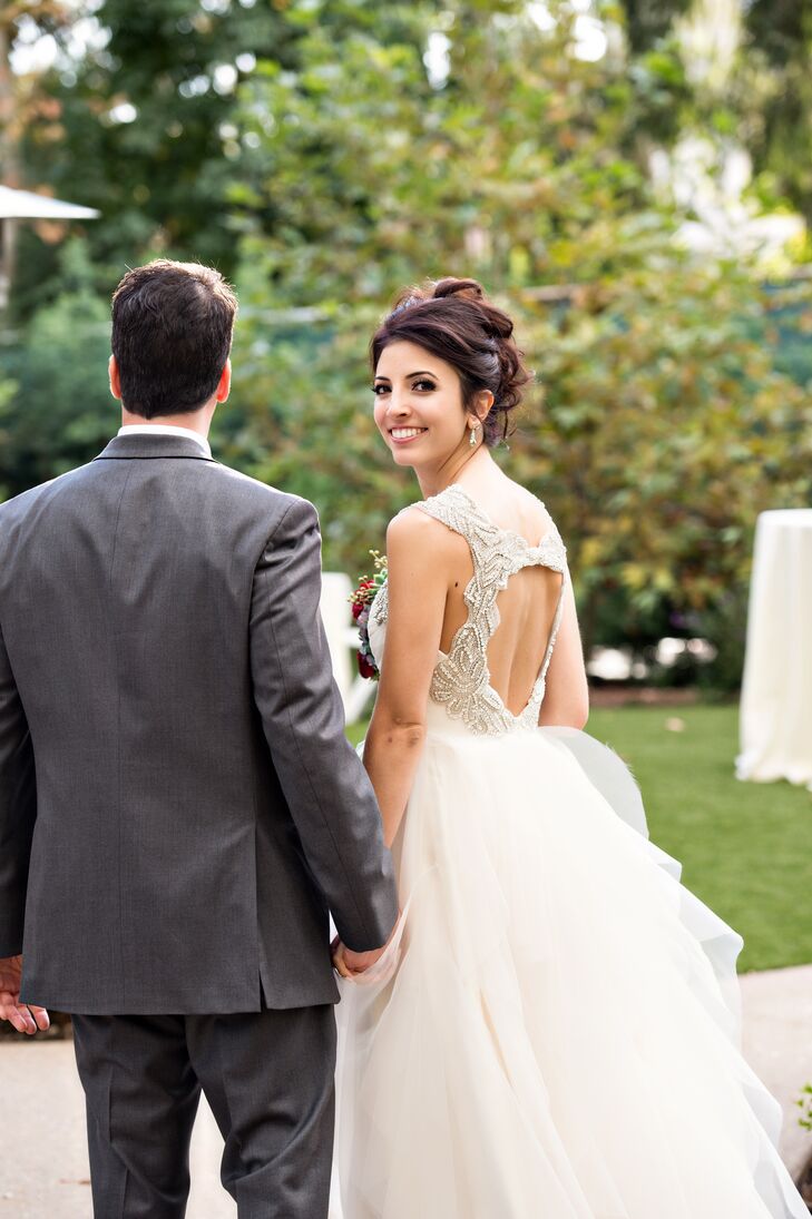 Lauren spotted Hayley Paige’s whimsical Carrie dress while searching for inspiration on Pinterest and was instantly smitten with its tiers of ethereal organza and showstopping back. “It made me feel like a fairy,” Lauren says. The bride-to-be decided against a veil, accessorizing her scene-stealing gown with an elegant updo and glitzy crystal earrings instead, for a look that exuded modern elegance and romance.
