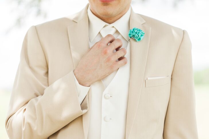 Tarik tied their wedding color, one of Cami’s favorite colors, into his look with a single accent. A Tiffany blue rosette served as a boutonniere on the lapel of his neutral suit from Men’s Wearhouse. His groomsmen wore matching Tiffany blue vests for some extra color.