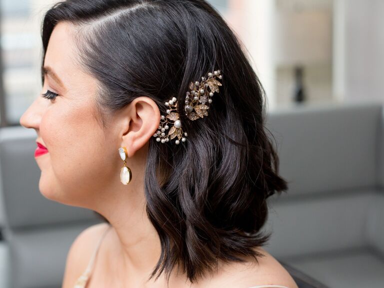 Beautiful bride shows off her elegant hairstyle featuring a retro hairpiece. 
