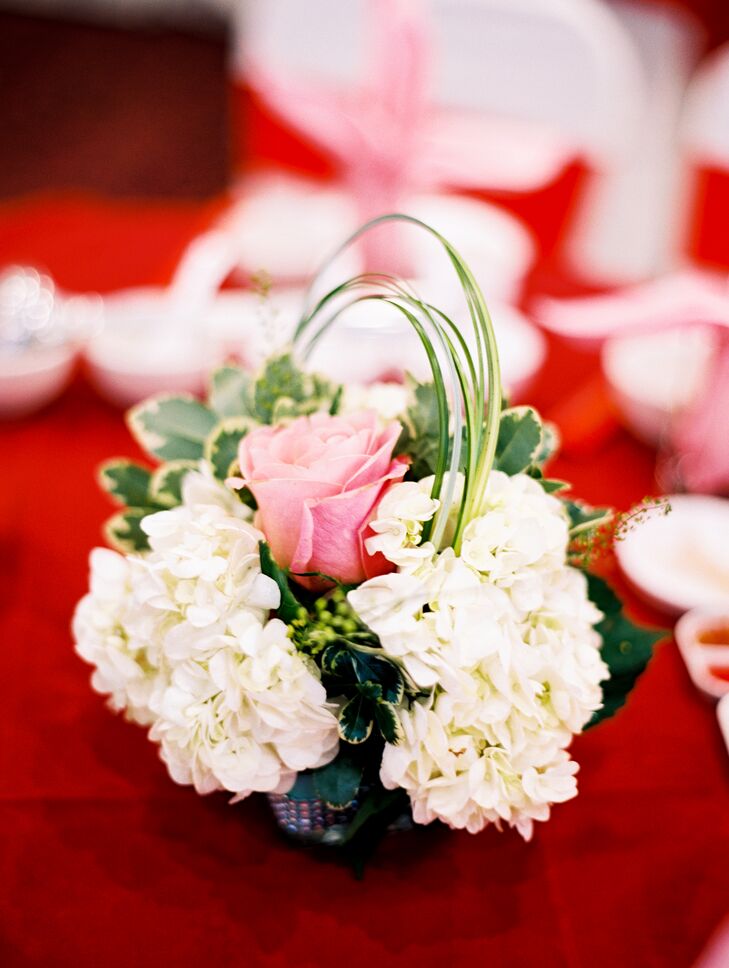 The focus of the reception was on the food and the couple delighted guests’ taste buds with a decadent 10-course meal. “With lots of food coming for the family-style dinner, we opted for smaller, shorter centerpieces,” says LeiLei. Each table was topped with an arrangement of fresh white hydrangeas, pink roses, variegated greenery and wispy grasses.