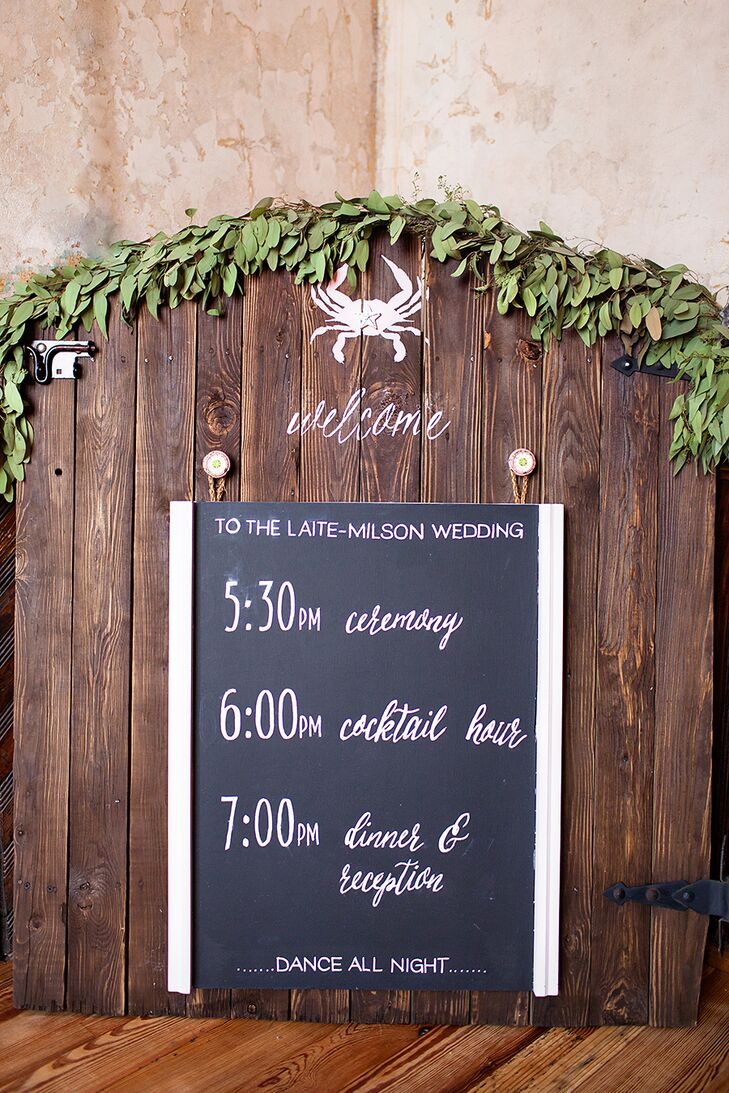 A handwritten chalkboard sign was used to give the guests a schedule for the night. It was hung rustic wood draped in fresh greenery, and as a tribute to Christi (a Maryland native) a little chalk crab was drawn on the top.