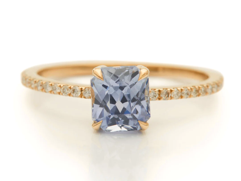 A yellow gold band with tiny diamonds alongside a square-cut sapphire.