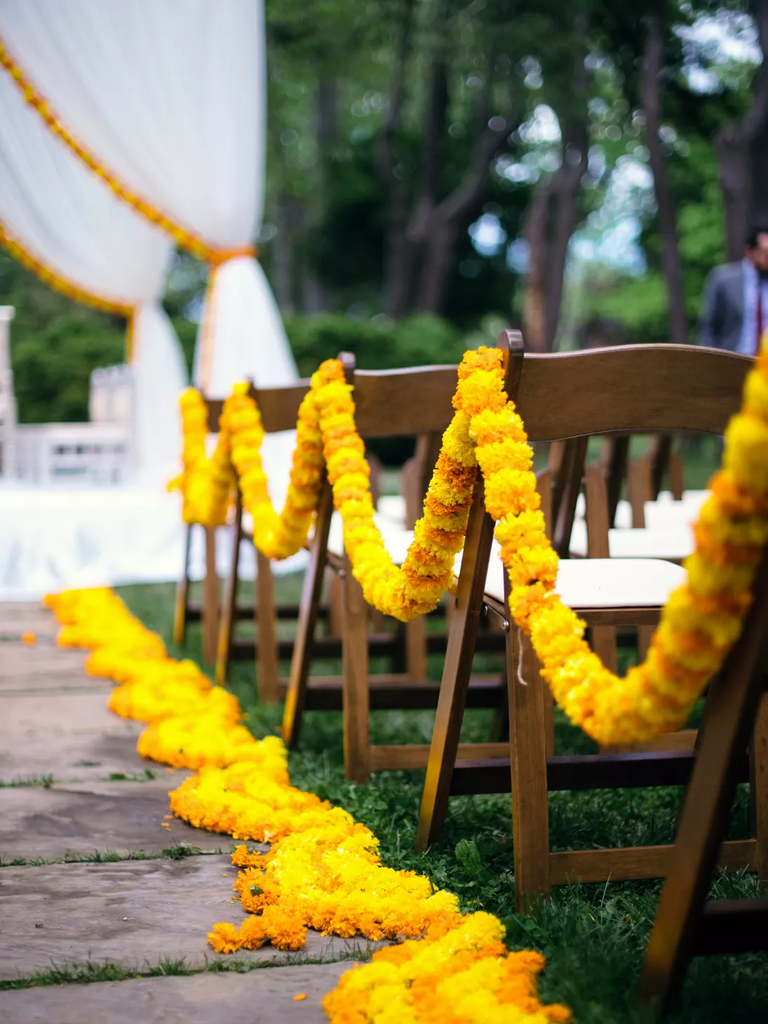 Vibrant yellow flower garlands lead guests to their seats.