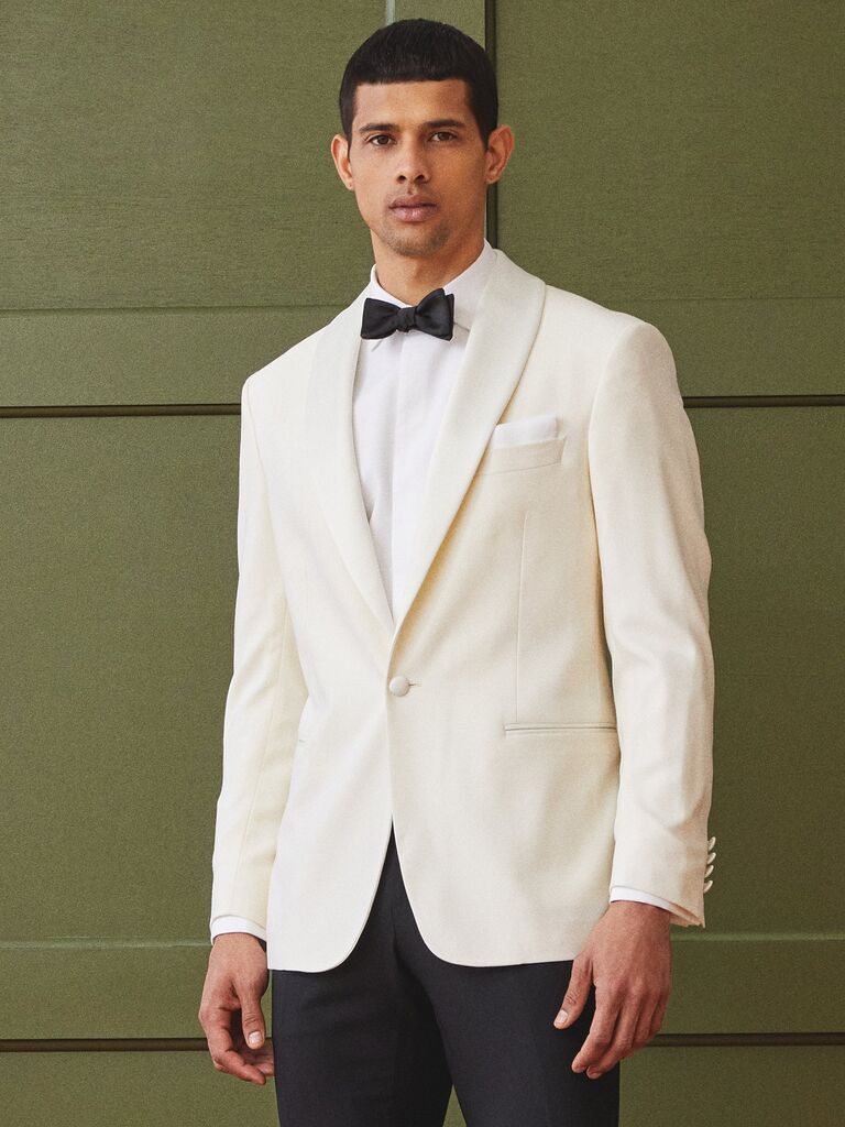 Model wears an ivory suit jacket with black bow tie and pants.