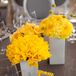 Arrangements of bright-yellow mums, tulips and craspedia topped some tables.