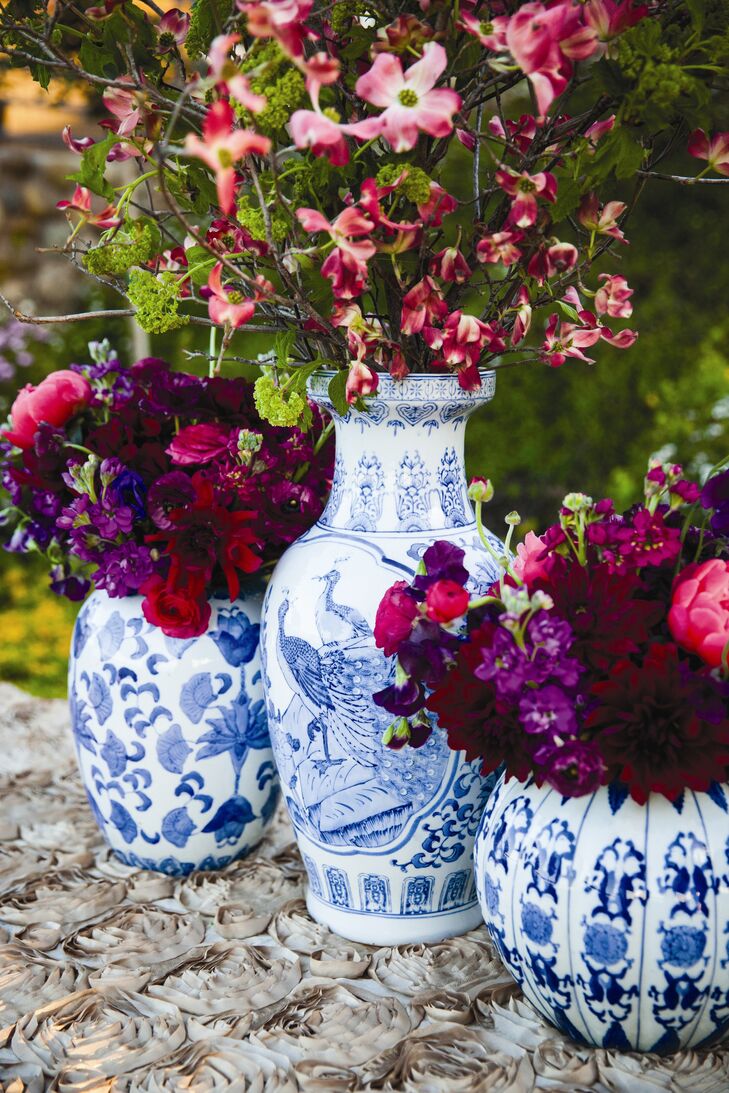 Large arrangements of fuchsia and purple flowers were placed in classic blue willow Chinese vases, adding color and sophistication to the decor.