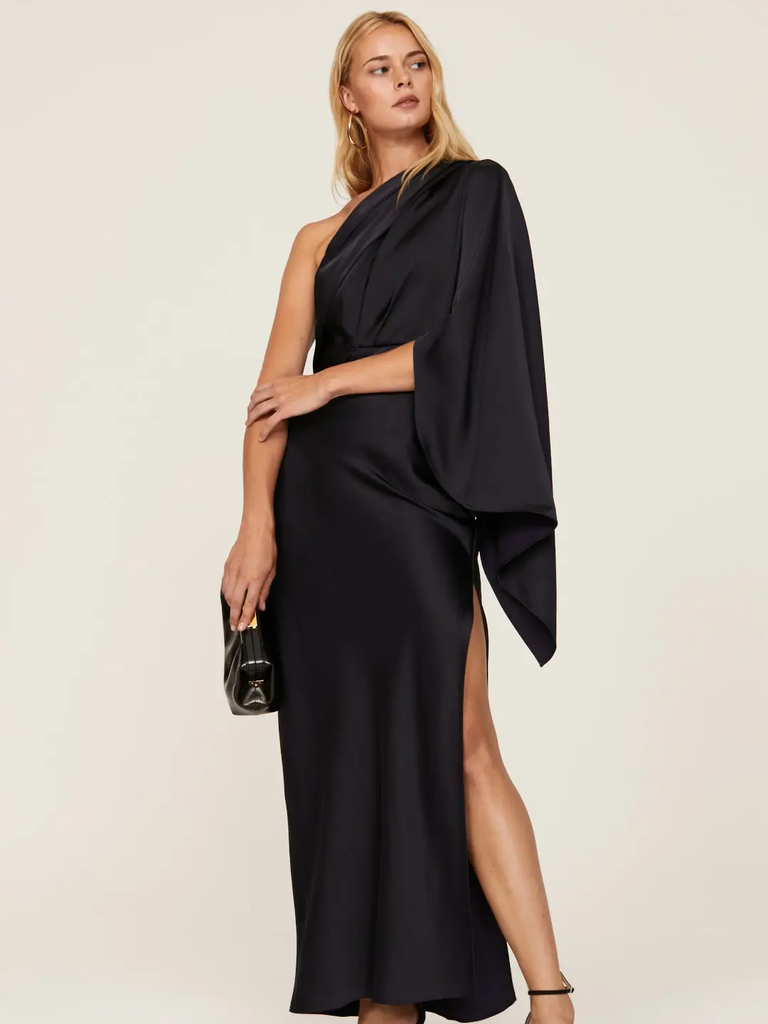 A model shows off this gorgeous black one-shouldered gown with a bell sleeve.