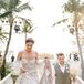 Bride in Gold Crown, Off-the-Shoulder Dress and Groom in Light Gray Suit Holding Bouquet in Recessional