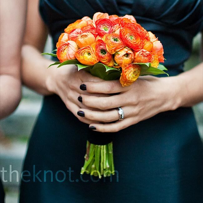 Erica's bridesmaids wore strapless black dresses and carried orange ranunculus bouquets wrapped in black.