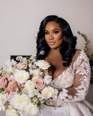 A Bride in a Wedding Dress With Illusion Sleeves and Lace Details Holding Blush Bouquet