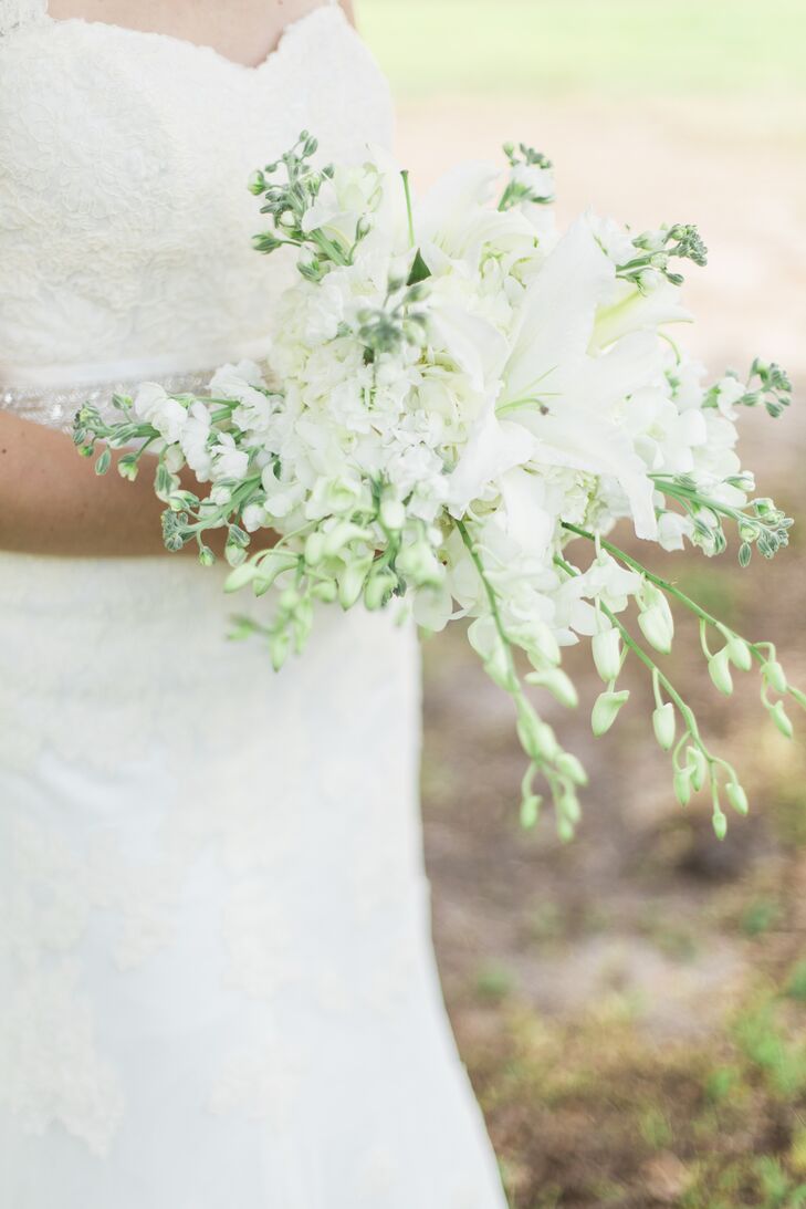 Cami picked up on their venue's scenery and chose a natural bouquet. White delphiniums cascaded from the arrangement as a bolder stargazer lily stood out at the center.