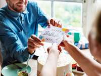 Wife handing husband birthday card