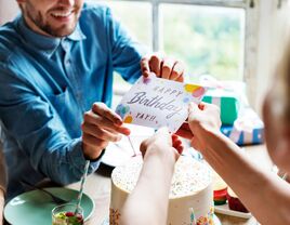 Wife handing husband birthday card