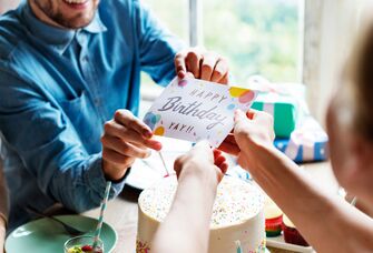 Wife handing husband birthday card