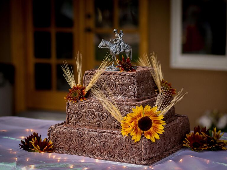 Square-shaped three-tiered wedding cake with a beautiful finish designed to look like leather detailing. 