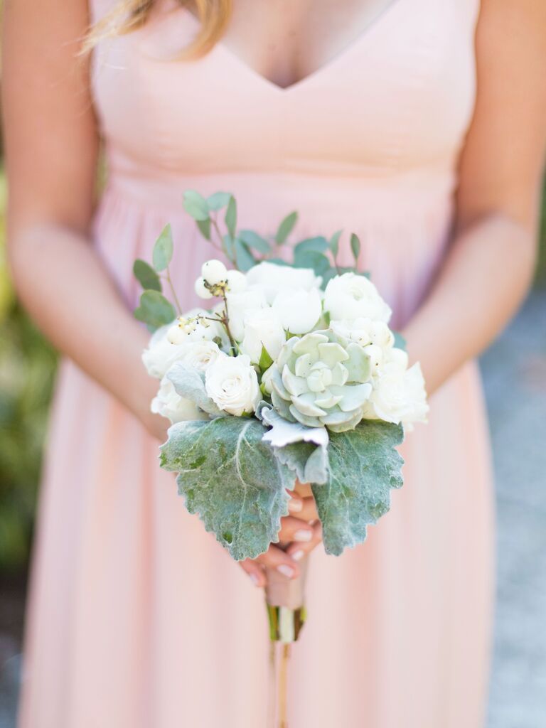 A bridesmaid holds this pale green and white bouquet.