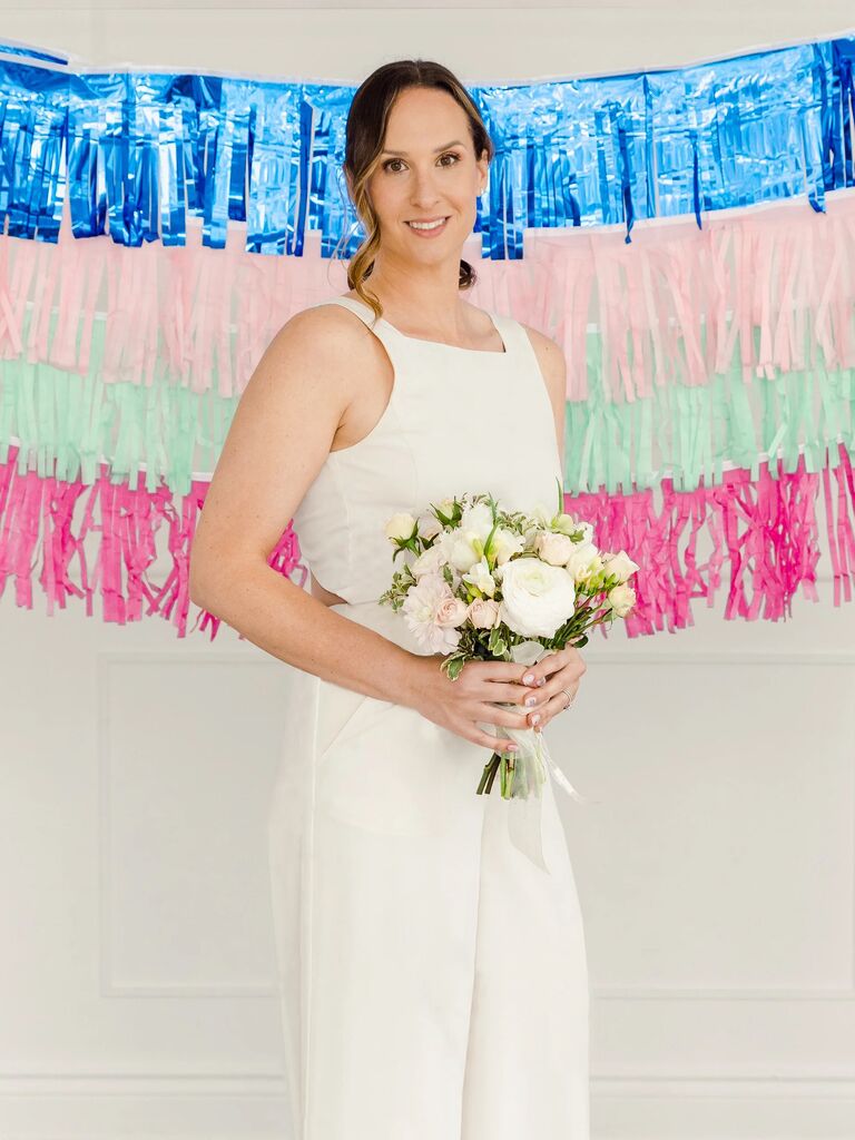 A model standing before a fun multi-colored bunting.