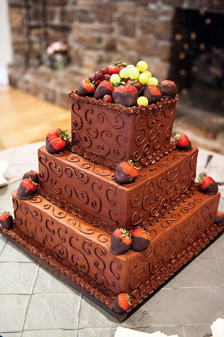 The groom's cake was a three-tiered chocolate cake with swirled piping topped with fresh fruit and chocolate-covered strawberries.