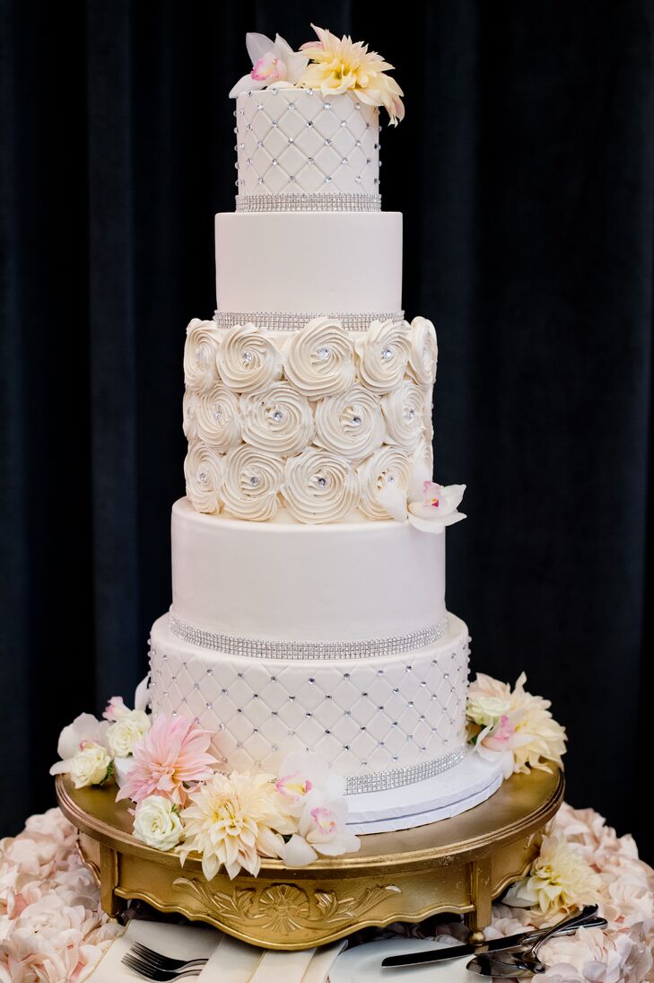 The cake's five tiers had different designs, including an iced rose center layer. It was vanilla cake with Italian buttercream frosting and fresh strawberry compote filling.