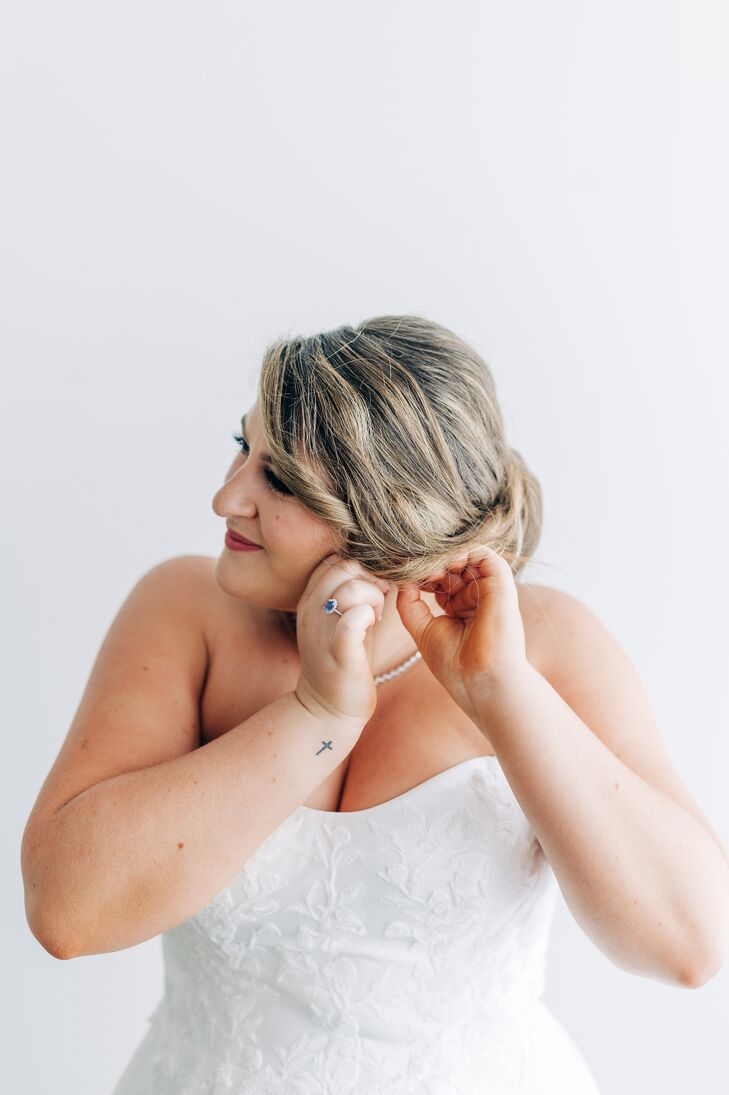 Bride in Sweetheart Gown With Elegant Updo Puts in Her Earrings