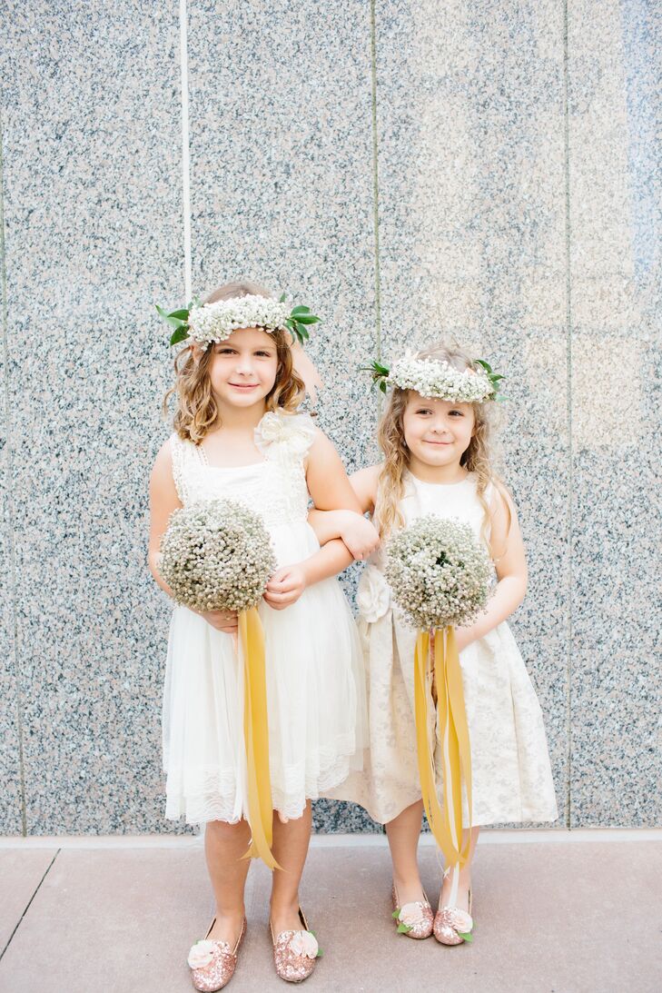 The flower girls wore their own ivory dresses. One was found on Etsy.com, and the other was by US Angels and found at Nordstrom Rack. They completed their look with lush baby's breath flower crowns and carried oversize round bouquets tied with long golden ribbons.
